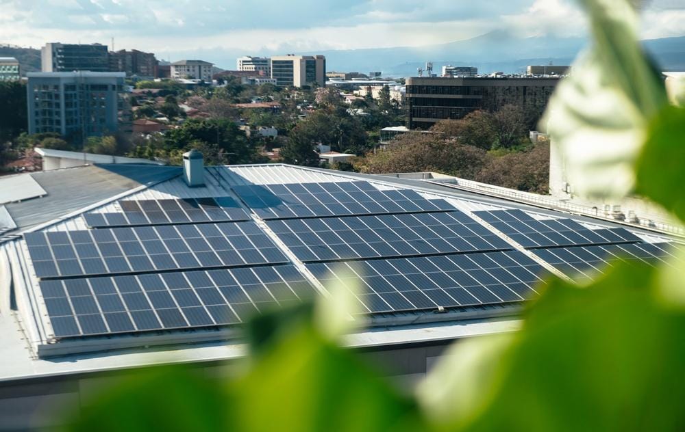 Rooftop view of a large commercial solar panel system installed on a factory in Thailand.